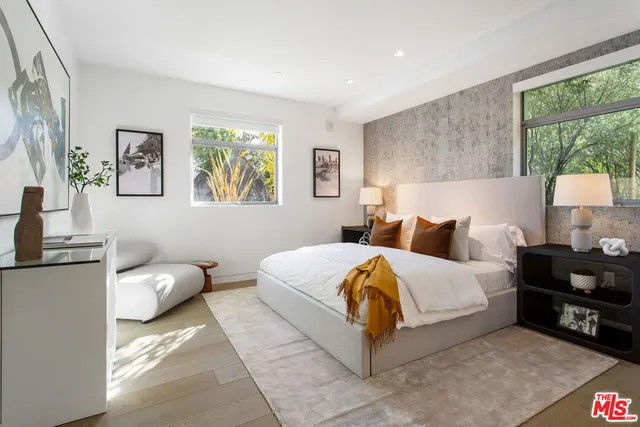 a bedroom with a bed and a painting on the wall