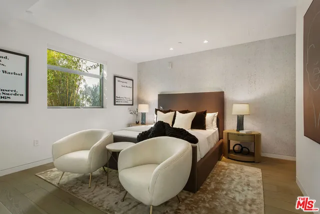 a bedroom with a bed lamp and a flat screen tv