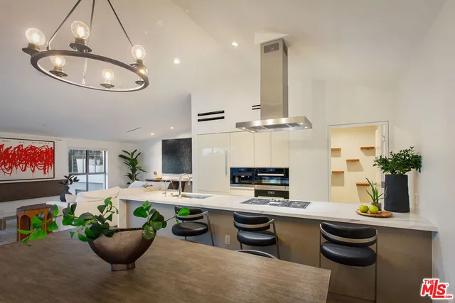 a kitchen with stainless steel appliances kitchen island granite countertop a table chairs a sink and a stove