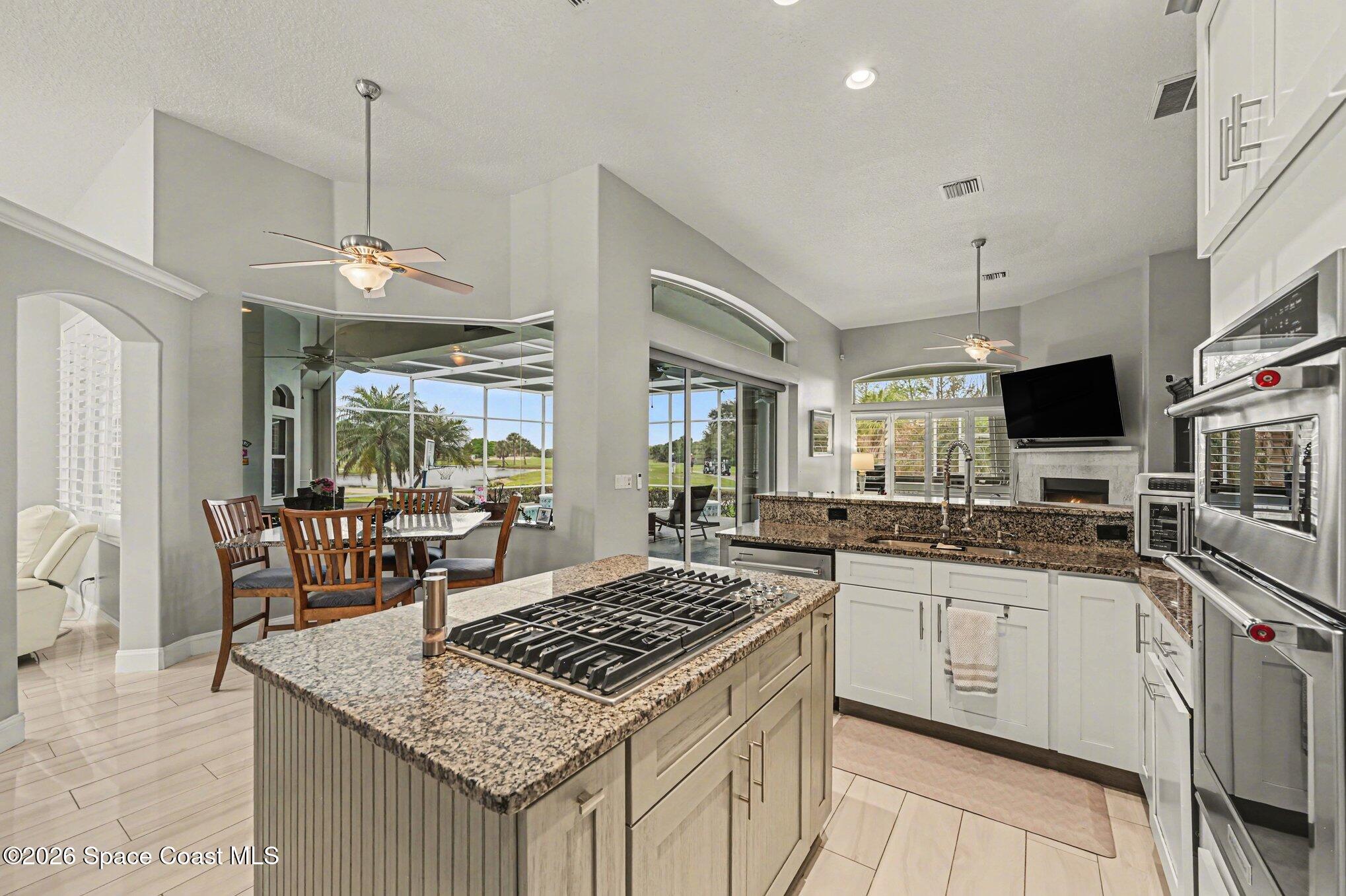 4317 Collingtree Drive Rockledge, FL 32955 - Photo 17 of 64 a kitchen with a stove a sink a dining table and chairs