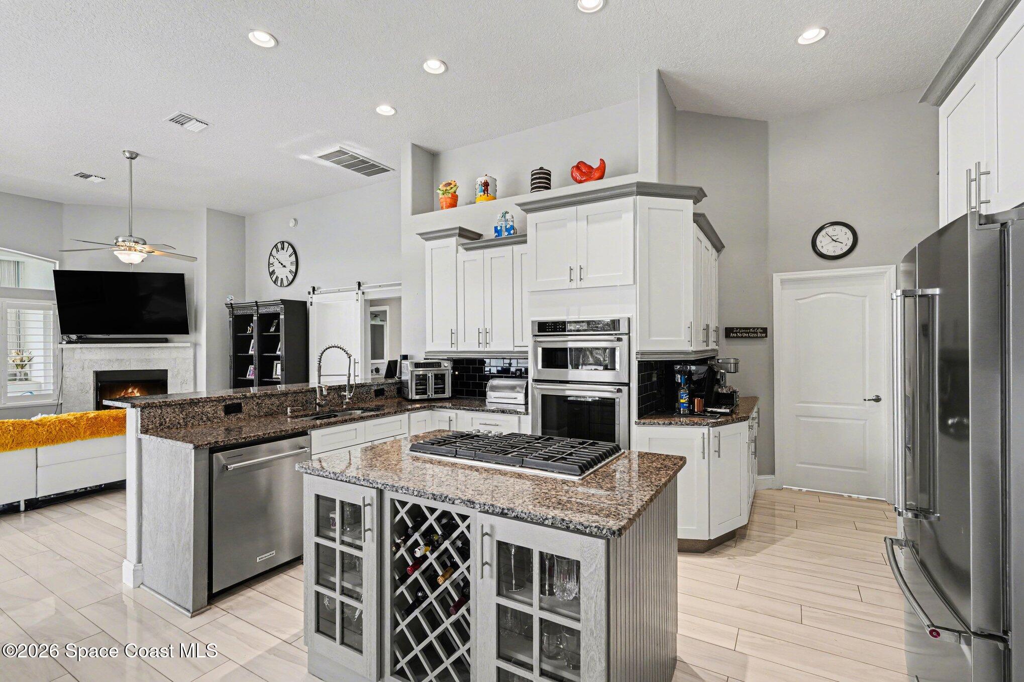 4317 Collingtree Drive Rockledge, FL 32955 - Photo 18 of 64 a kitchen with granite countertop a sink and a stove top oven with wooden floor
