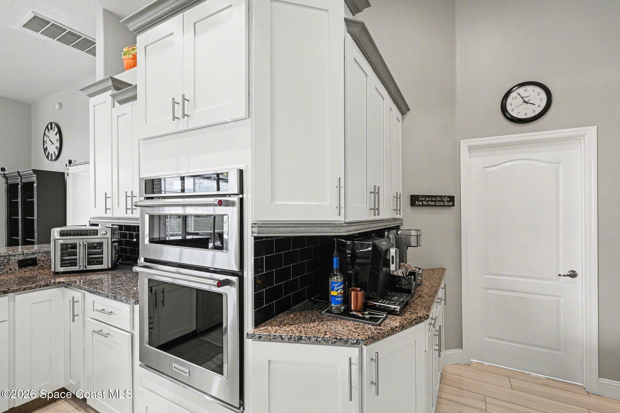4317 Collingtree Drive Rockledge, FL 32955 - Photo 19 of 64 a kitchen with white cabinets and appliances