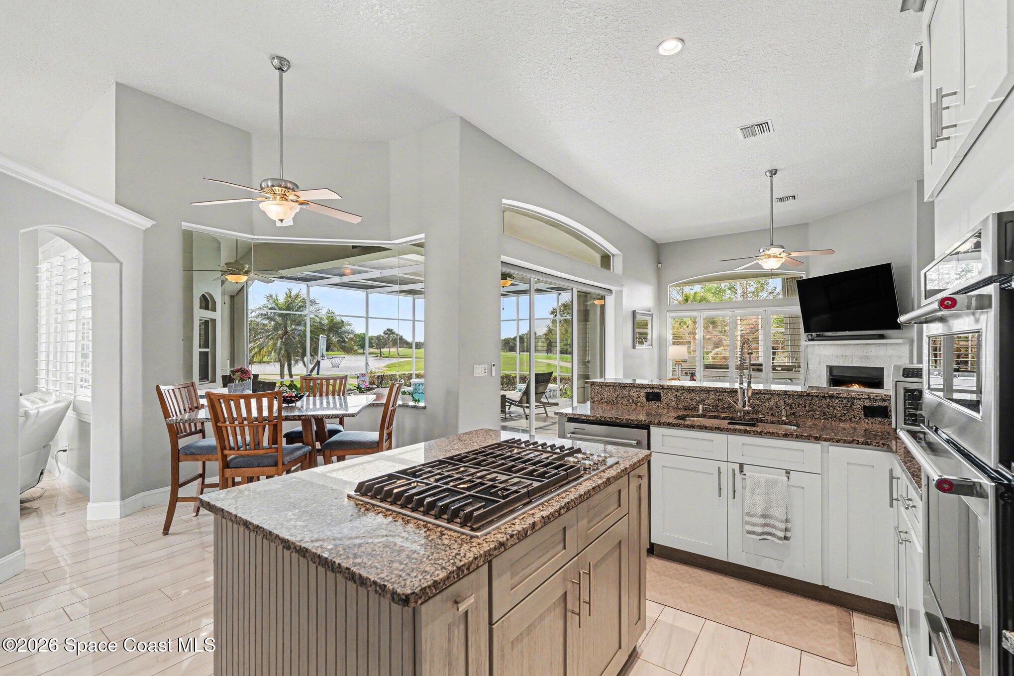4317 Collingtree Drive Rockledge, FL 32955 - Photo 20 of 64 a kitchen with a stove a sink a dining table and chairs