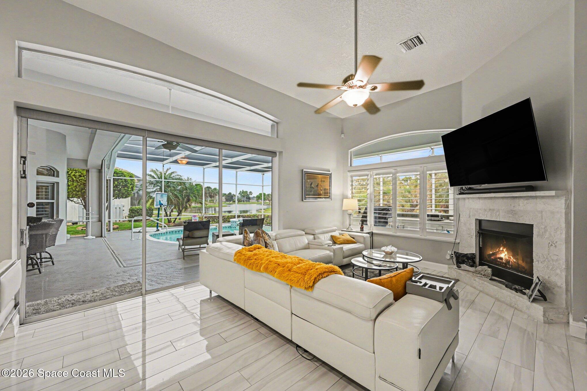 4317 Collingtree Drive Rockledge, FL 32955 - Photo 26 of 64 a living room with furniture fireplace and a flat screen tv