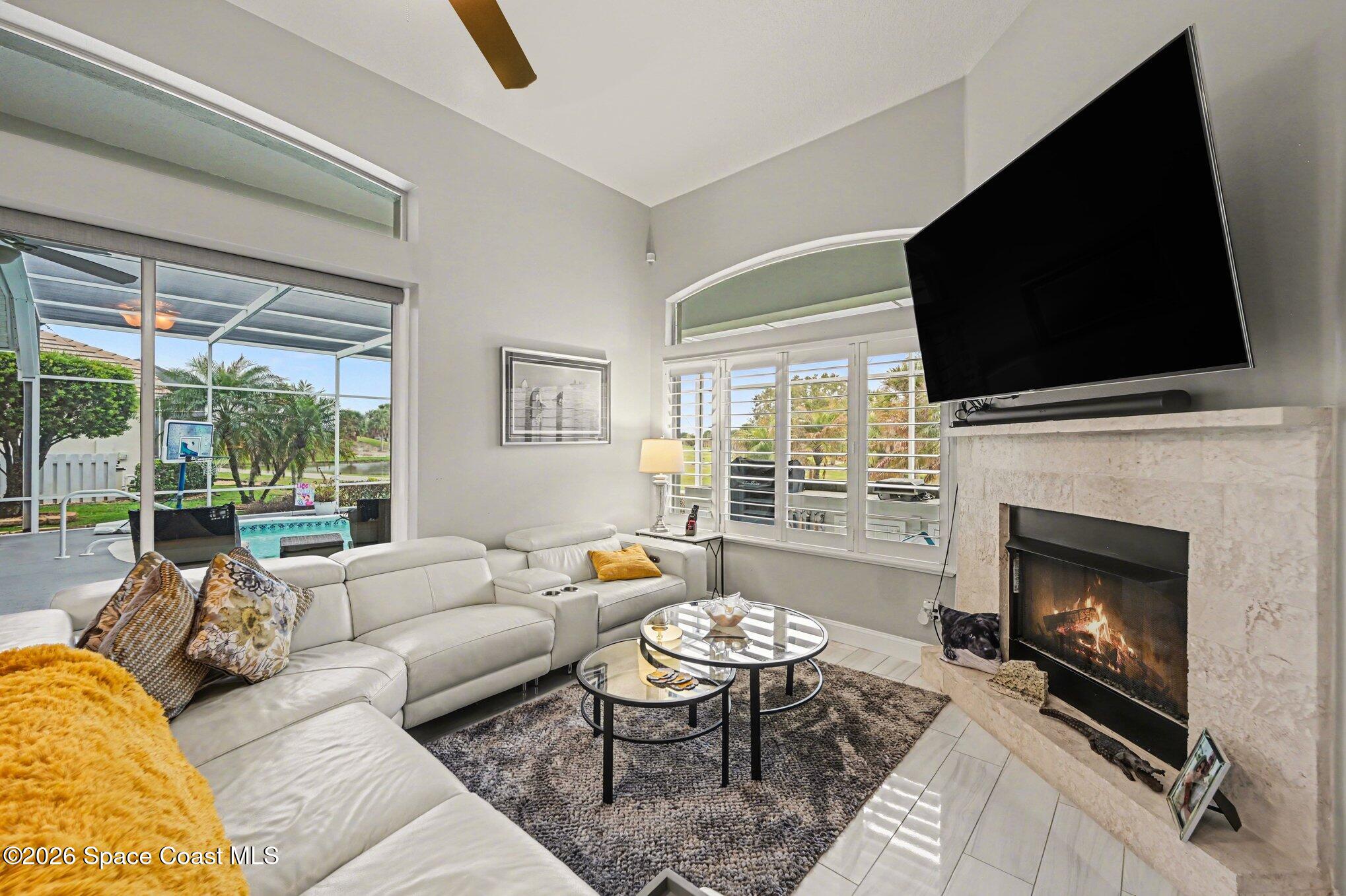 4317 Collingtree Drive Rockledge, FL 32955 - Photo 27 of 64 a living room with furniture a flat screen tv and a fireplace