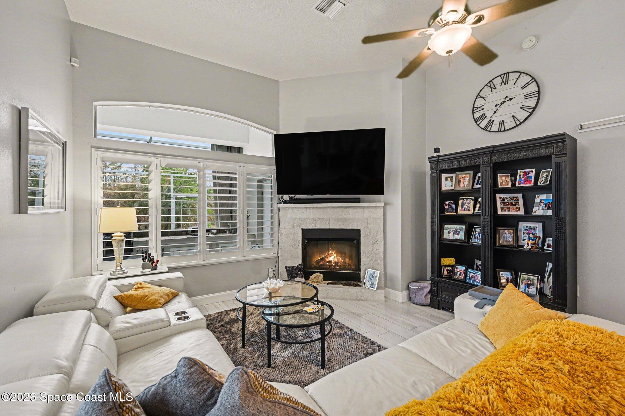 4317 Collingtree Drive Rockledge, FL 32955 - Photo 28 of 64 a living room with furniture a flat screen tv and a fireplace