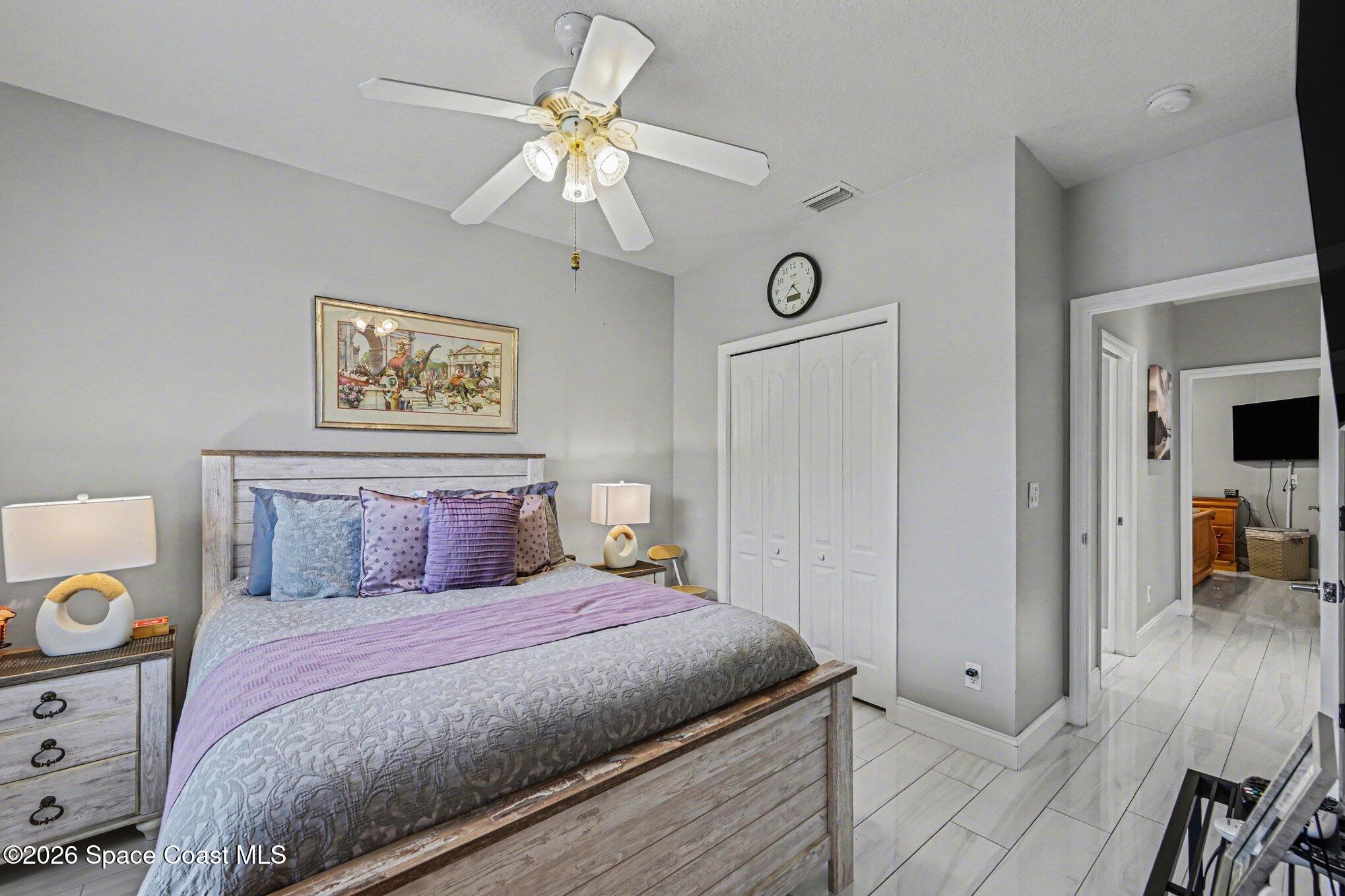 4317 Collingtree Drive Rockledge, FL 32955 - Photo 31 of 64 a bedroom with a large bed and a chandelier