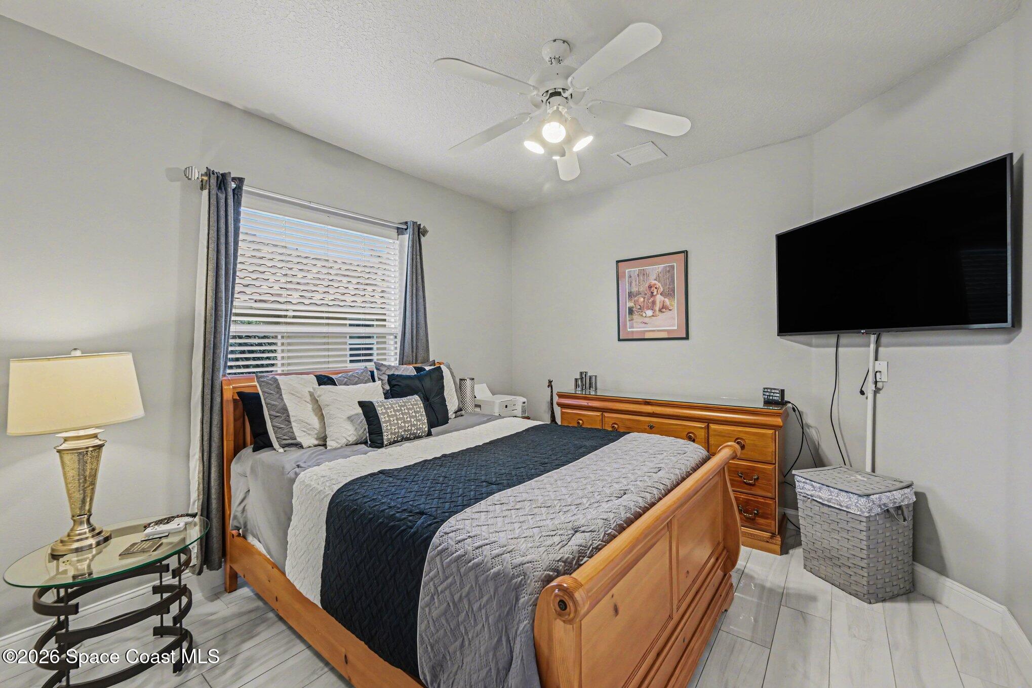 4317 Collingtree Drive Rockledge, FL 32955 - Photo 32 of 64 a bedroom with a bed and a flat screen tv