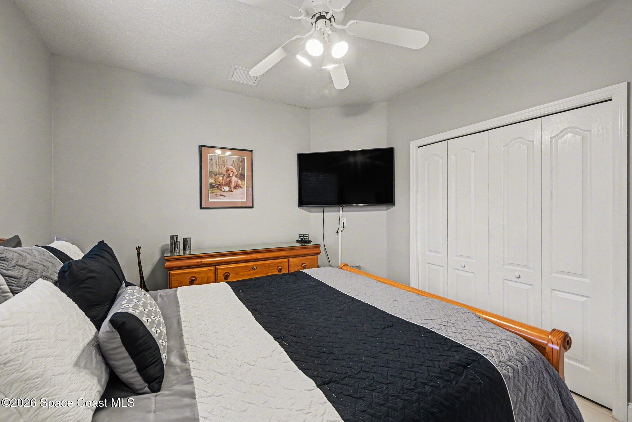 4317 Collingtree Drive Rockledge, FL 32955 - Photo 33 of 64 a bedroom with a bed and a flat tv screen on the dresser