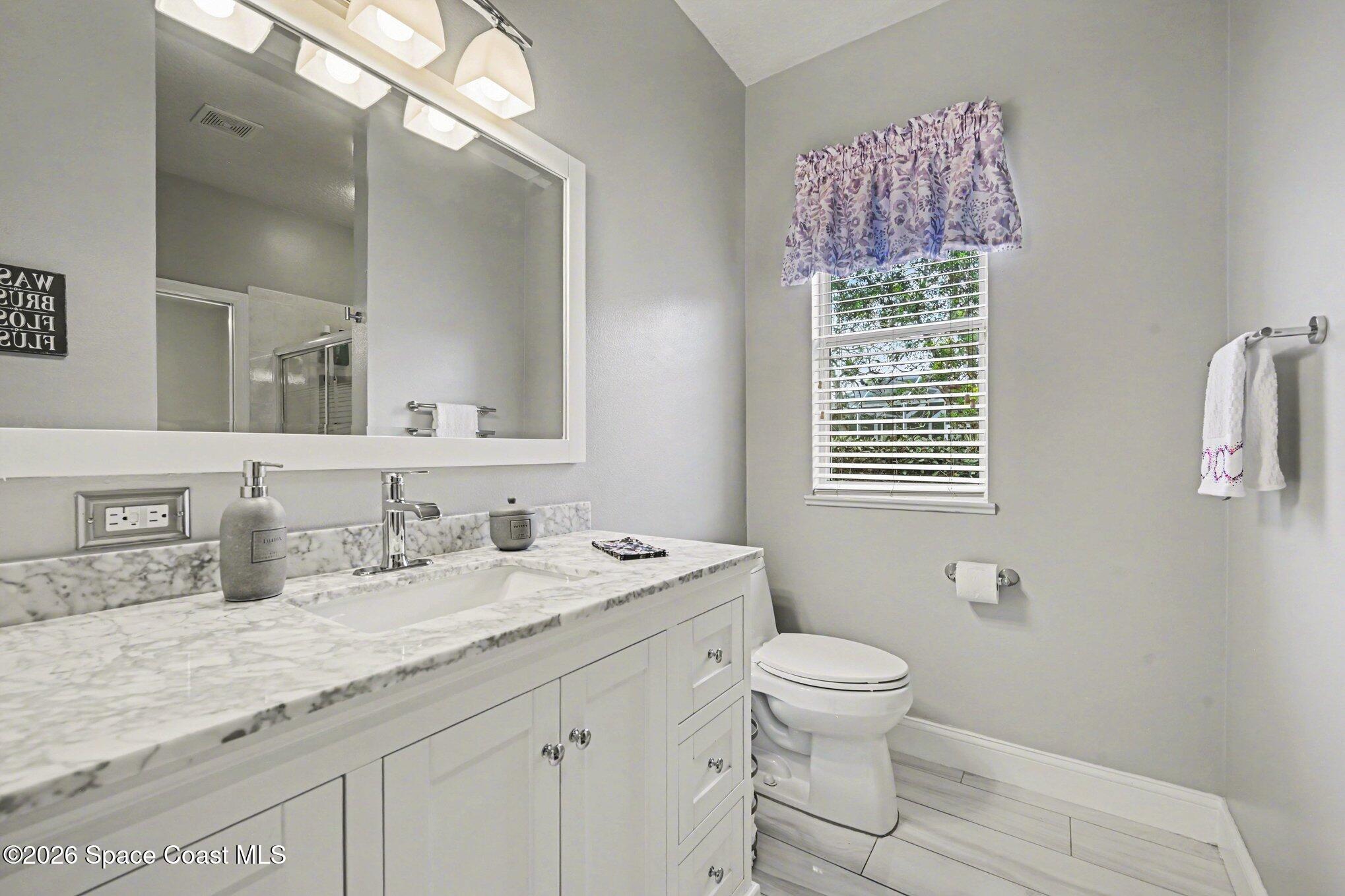 4317 Collingtree Drive Rockledge, FL 32955 - Photo 35 of 64 a bathroom with a granite countertop sink a toilet and a mirror