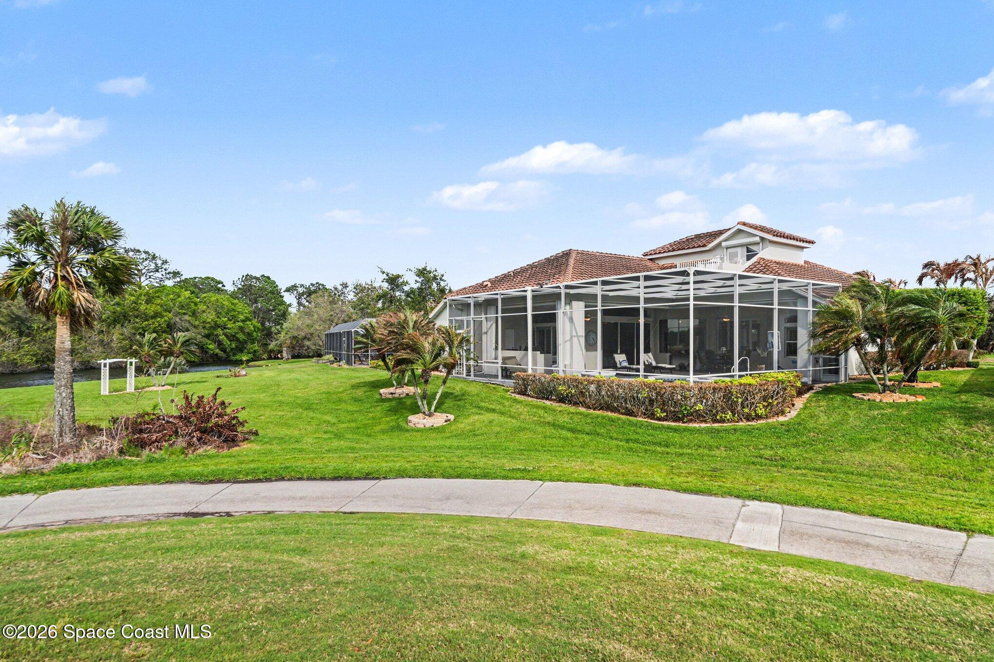 4317 Collingtree Drive Rockledge, FL 32955 - Photo 52 of 64 a view of a house with a big yard and potted plants and large trees