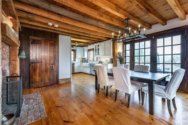 a view of a dining room with furniture a chandelier and wooden floor