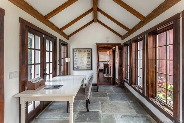 a bedroom with a large bed a chandelier and windows