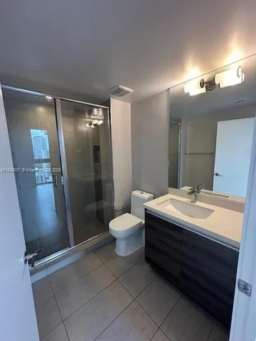a bathroom with a double vanity sink mirror and toilet