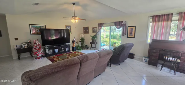 a living room with furniture a window and a flat screen tv
