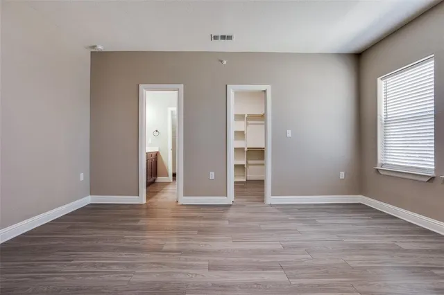 a view of empty room with wooden floor and window