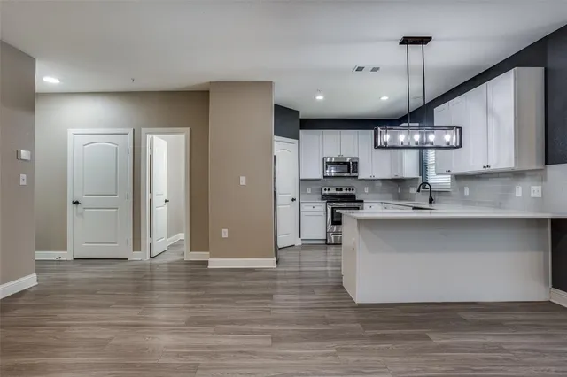 a kitchen with stainless steel appliances granite countertop a sink a refrigerator and a stove