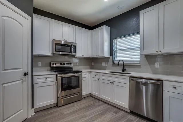 a kitchen with stainless steel appliances granite countertop a stove a sink and a microwave