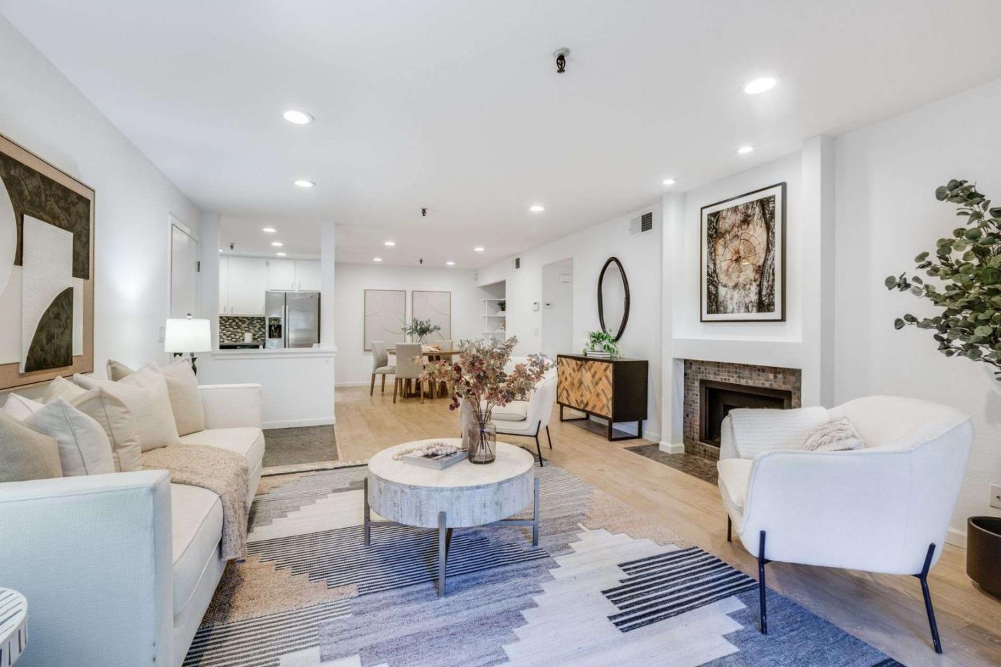 49 Showers Drive, Unit E152 Mountain View, CA 94040 - Photo 2 of 27 a living room with furniture a fireplace and a kitchen view