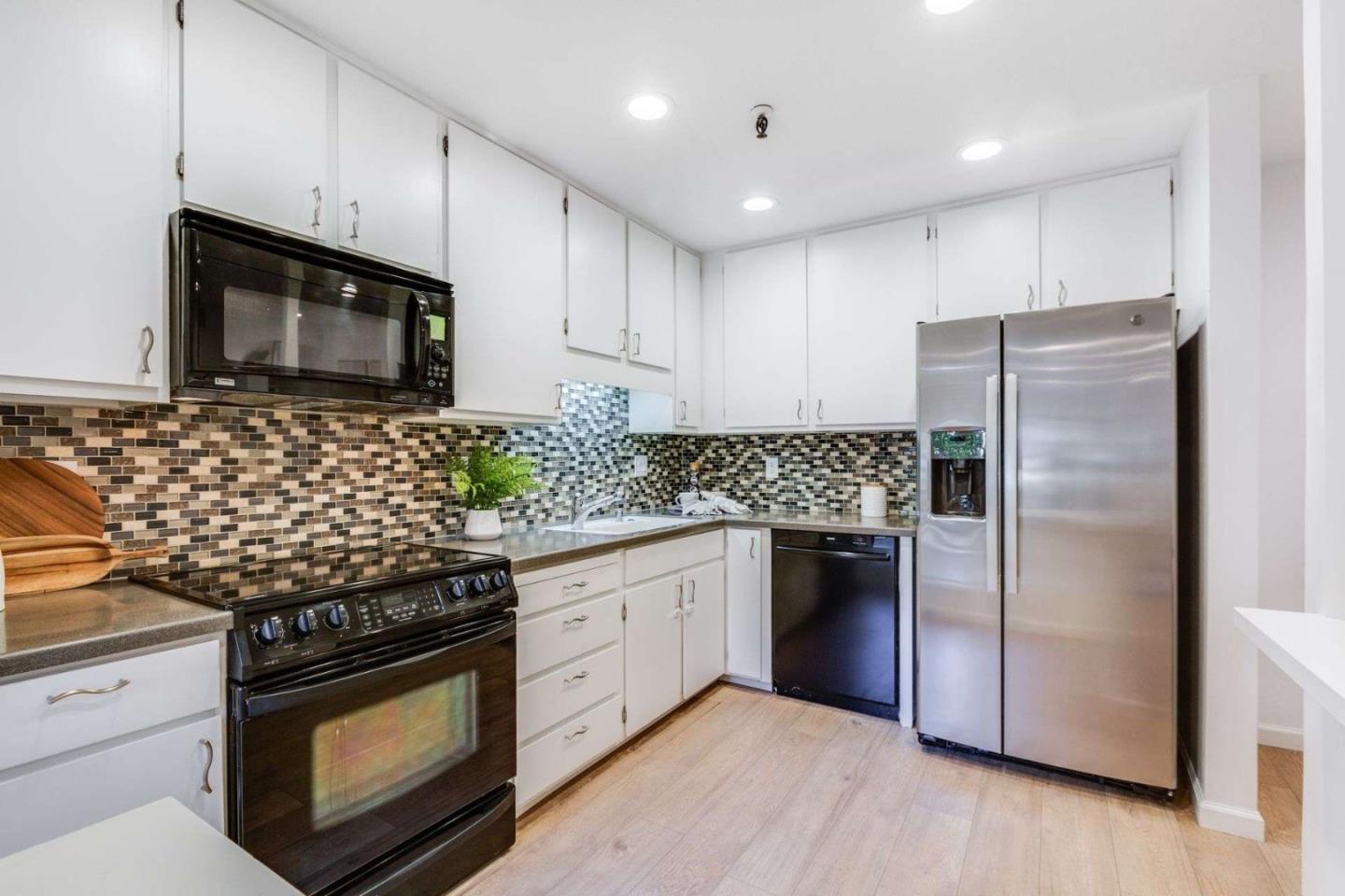 49 Showers Drive, Unit E152 Mountain View, CA 94040 - Photo 5 of 27 a kitchen with granite countertop stainless steel appliances and wooden cabinets