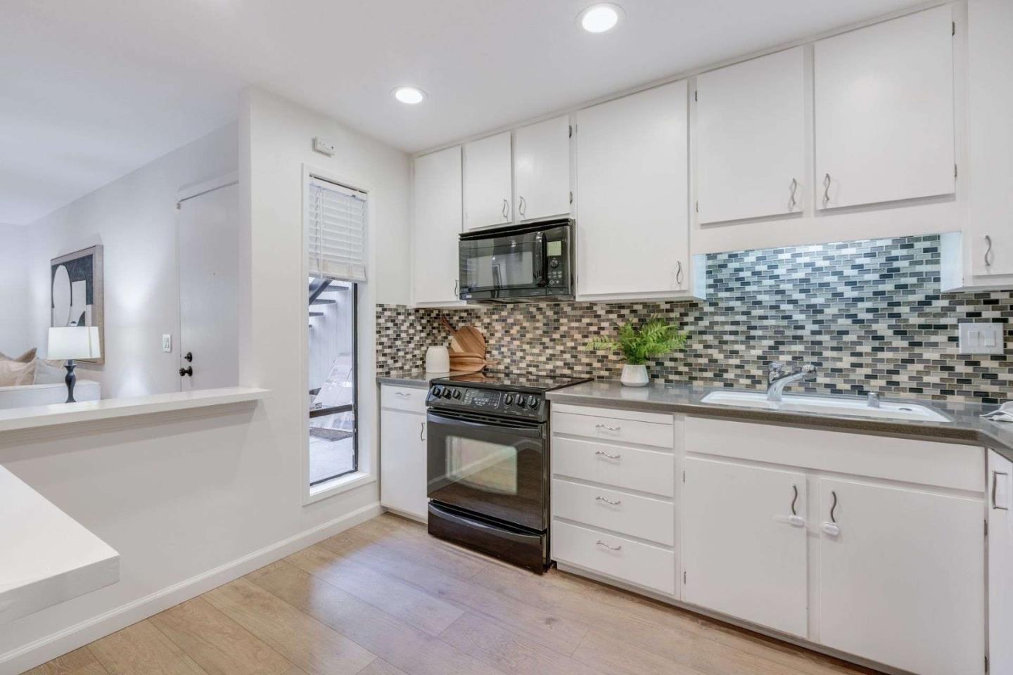 49 Showers Drive, Unit E152 Mountain View, CA 94040 - Photo 6 of 27 a kitchen with white cabinets and appliances
