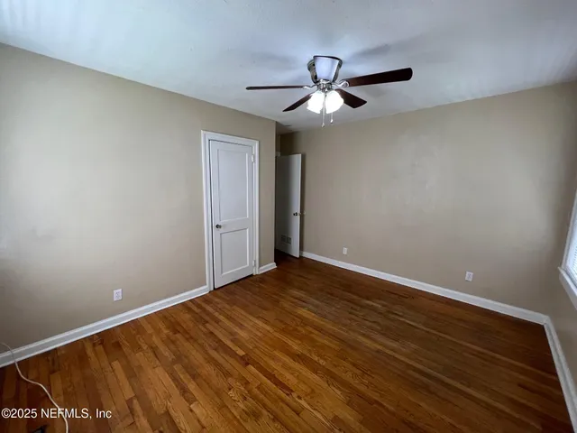 a view of empty room with wooden floor