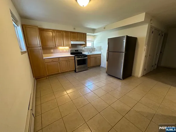 a kitchen with a refrigerator sink and cabinets