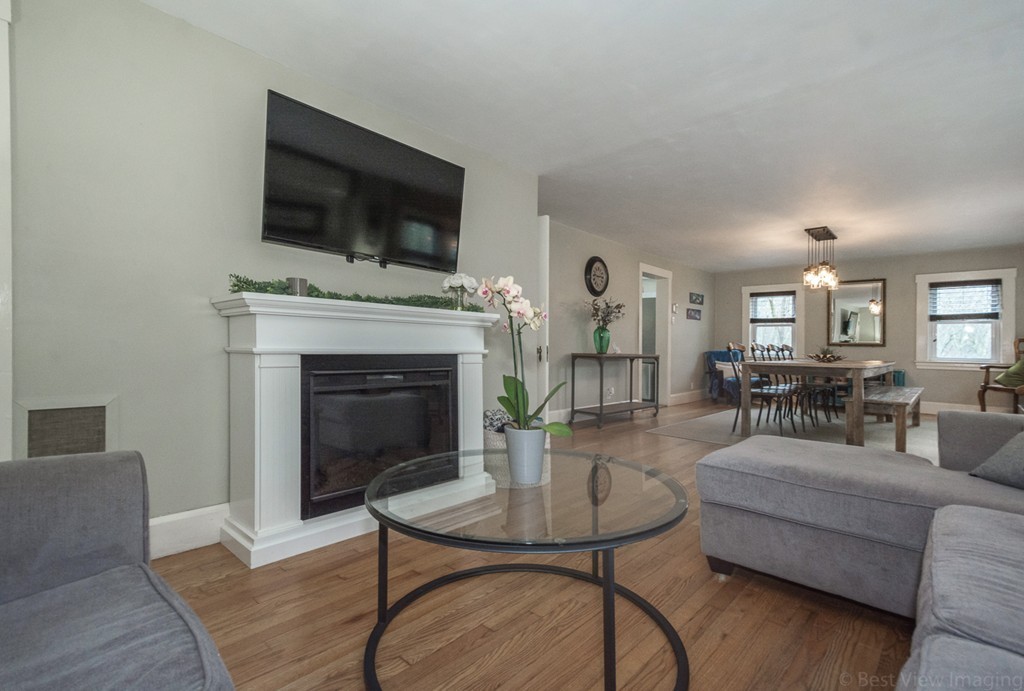 33 Burnham Road Bolton, MA 01740 - Photo 10 of 26 a living room with furniture a fireplace and a flat screen tv