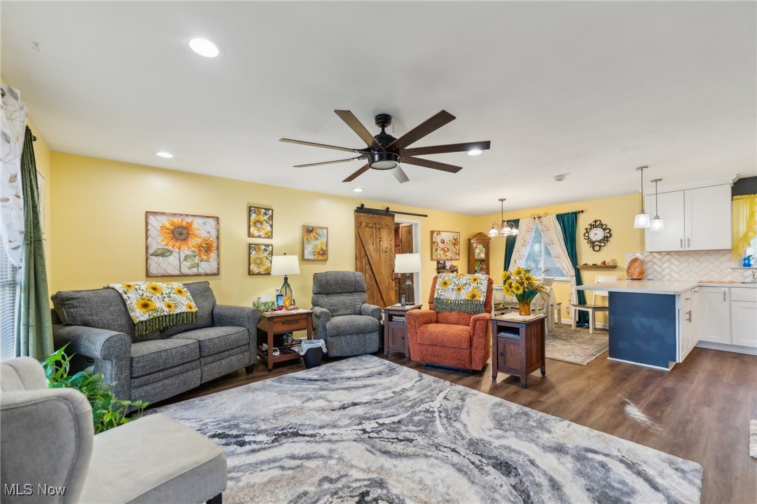 3885 Shields Road Canfield, OH 44406 - Photo 23 of 38 Living area featuring a barn door, dark wood finished floors, ceiling fan, recessed lighting, and a chandelier