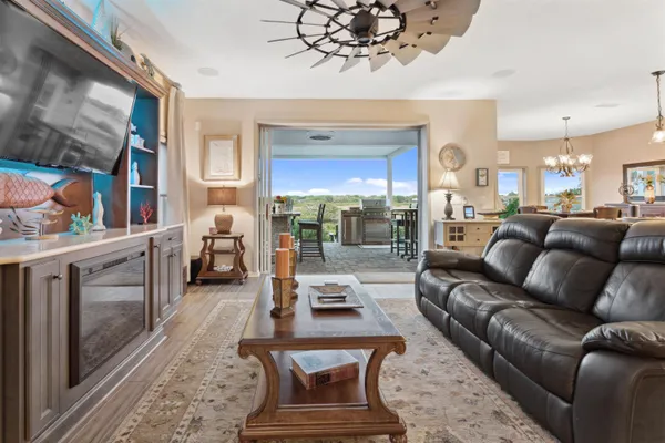 a view of a dining room with furniture a chandelier and wooden floor