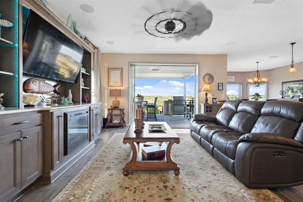 a view of a dining room with furniture a chandelier and wooden floor