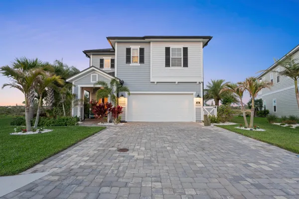 a view of a house with a yard and potted plants