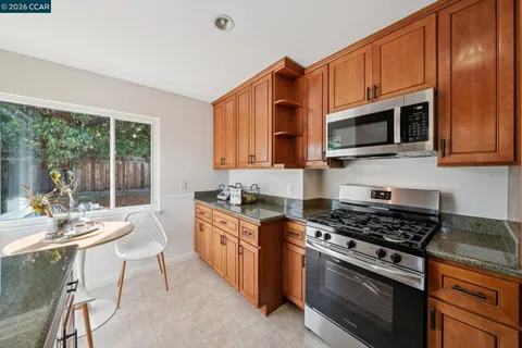 a kitchen with stainless steel appliances a stove a sink cabinets and a microwave
