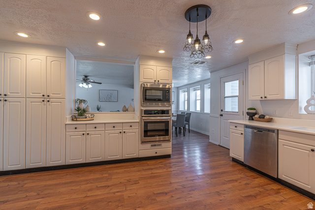 1045 Fox Farm Road Logan, UT 84321 - Photo 19 of 65 Kitchen featuring white cabinets, appliances with stainless steel finishes, light countertops, recessed lighting, and a textured ceiling