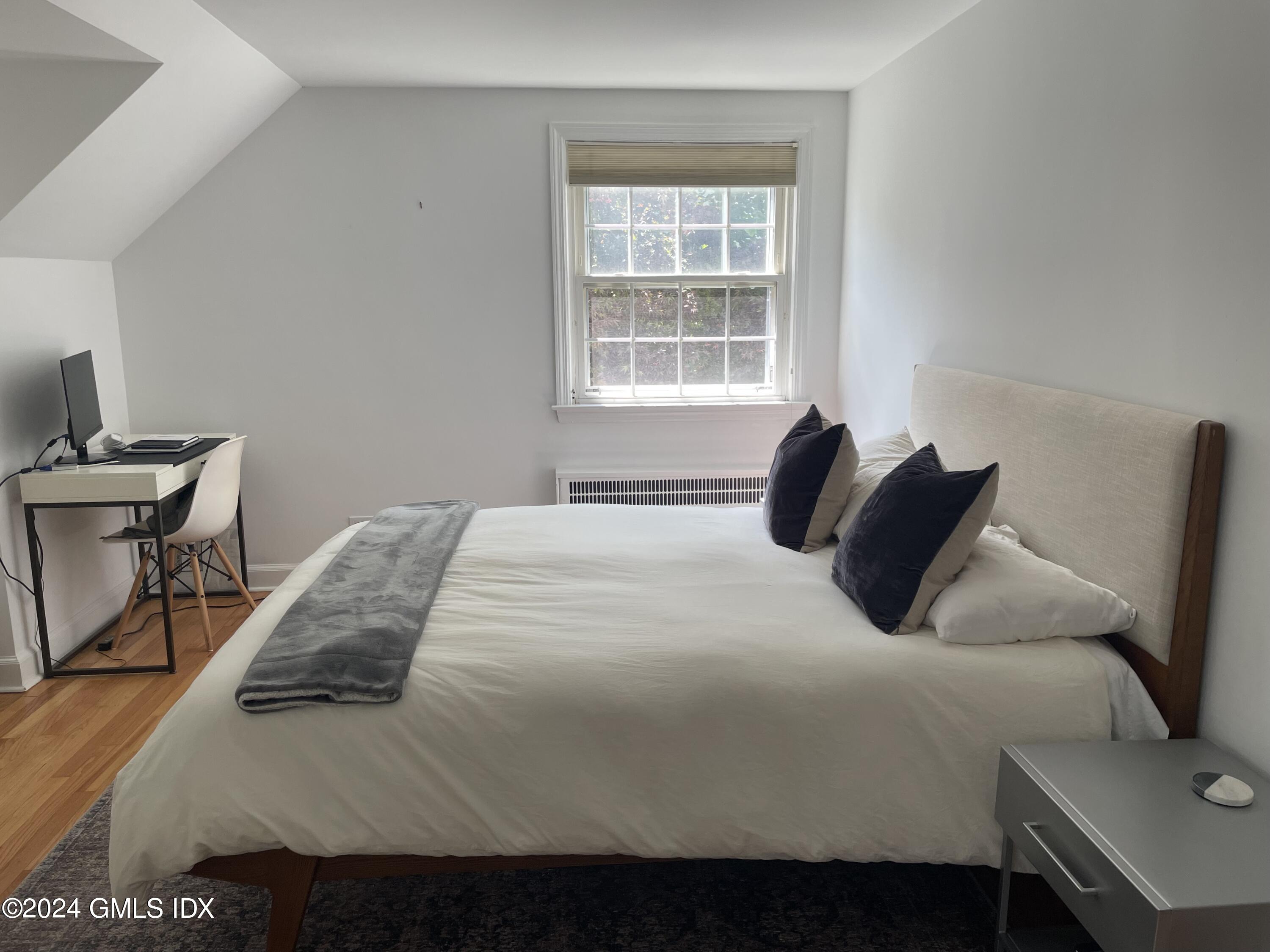 7 River Lane Cos Cob, CT 06807 - Photo 13 of 30 a bedroom with a bed and a chair