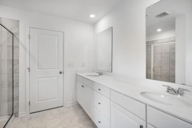 a bathroom with a double vanity sink and mirror