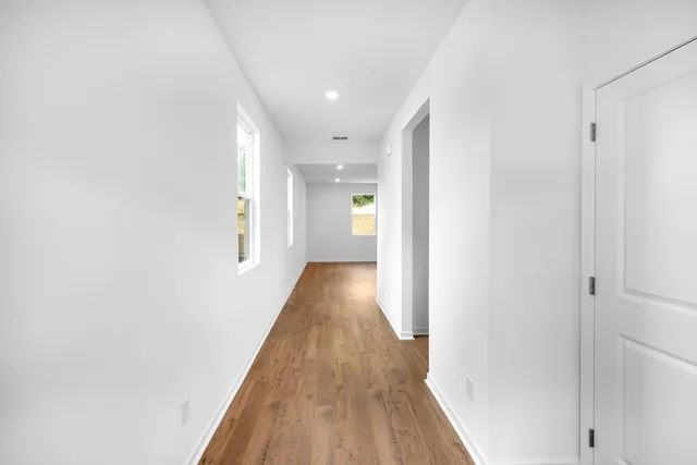 a view of a hallway with wooden floor