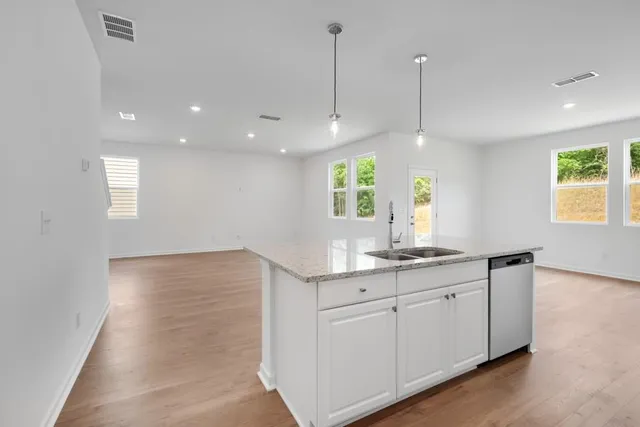 a kitchen with kitchen island white cabinets appliances and a chandelier