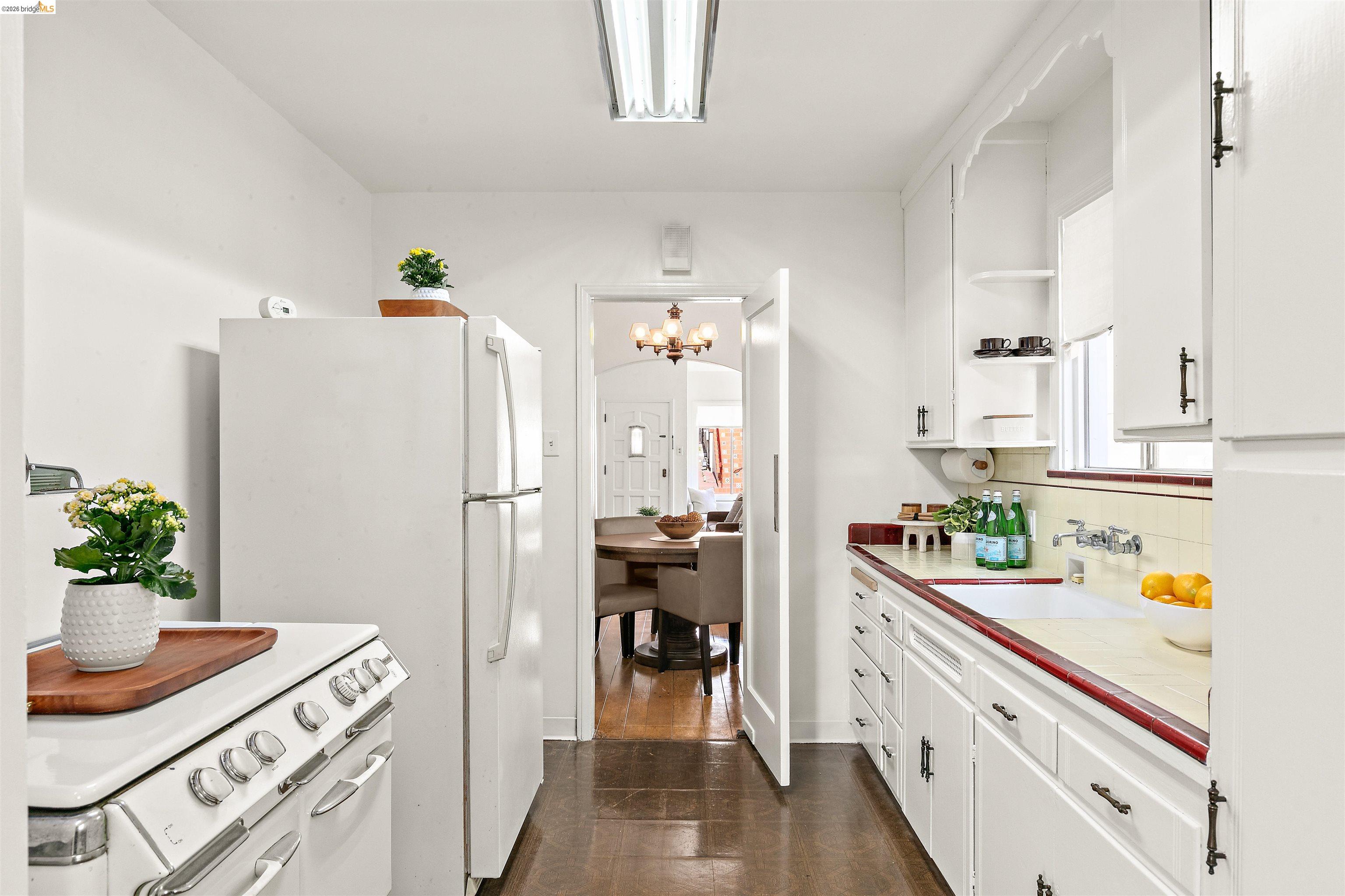 910 Pierce Street Albany, CA 94706 - Photo 8 of 44 a kitchen with a refrigerator and countertop white cabinets
