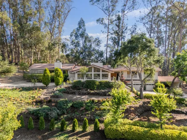 a front view of a house with a yard and fountain