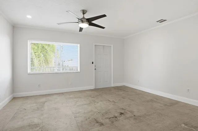an empty room with a window and a fan