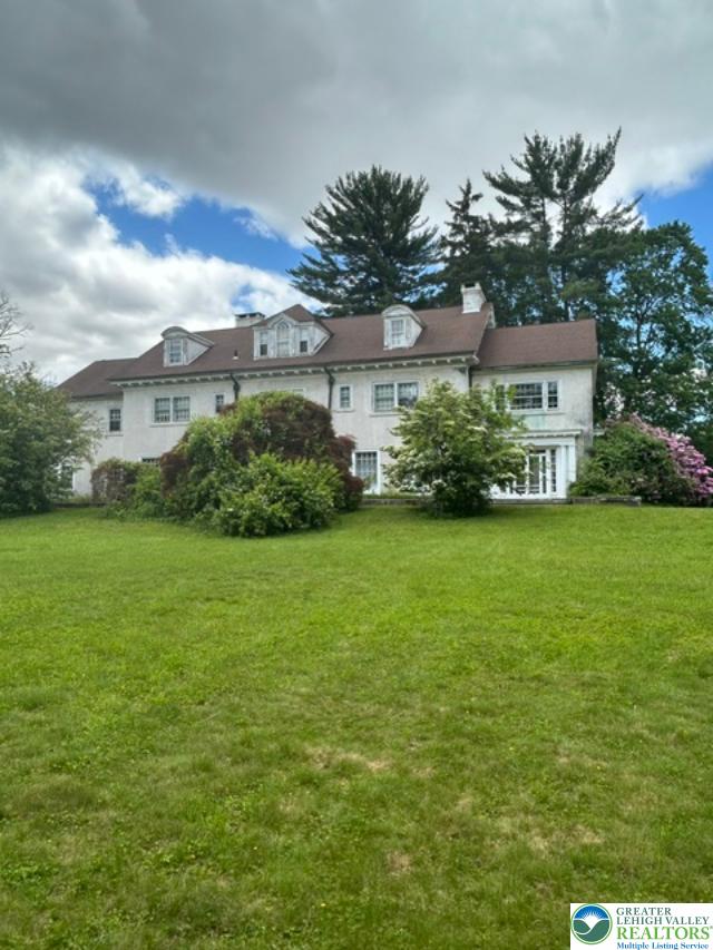 1170 Mosser Road Breinigsville, PA 18031 - Photo 2 of 19 An inviting exterior, framed by established greenery, promises serene living in this distinguished estate.