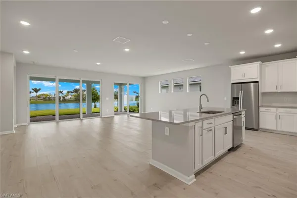 a kitchen with white cabinets and refrigerator
