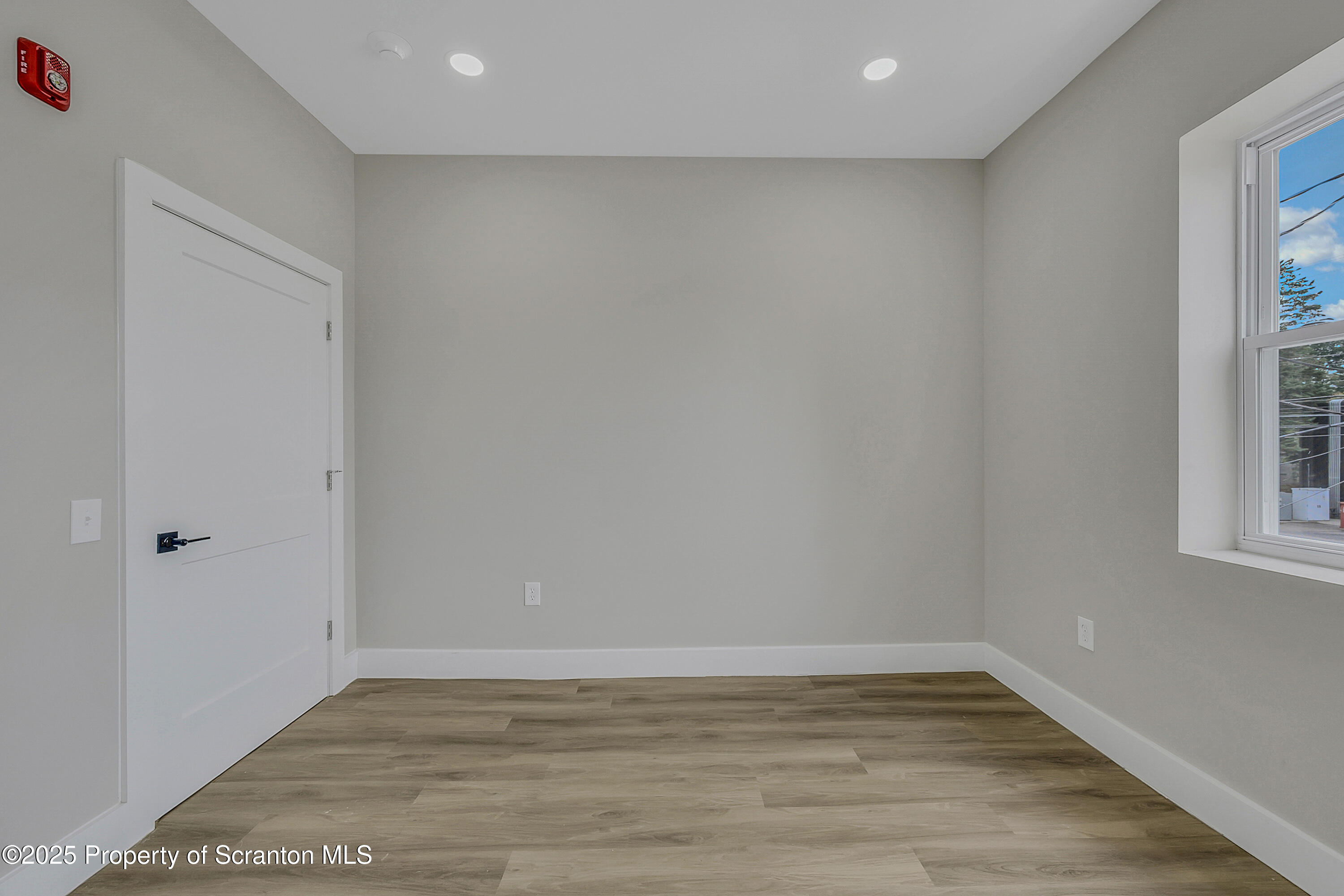 215 Hickory Street, Unit 8 Scranton, PA 18505 - Photo 11 of 18 a view of an empty room with wooden floor and a window