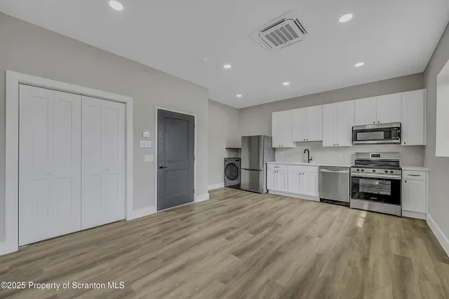 a kitchen with stainless steel appliances a refrigerator and a stove top oven