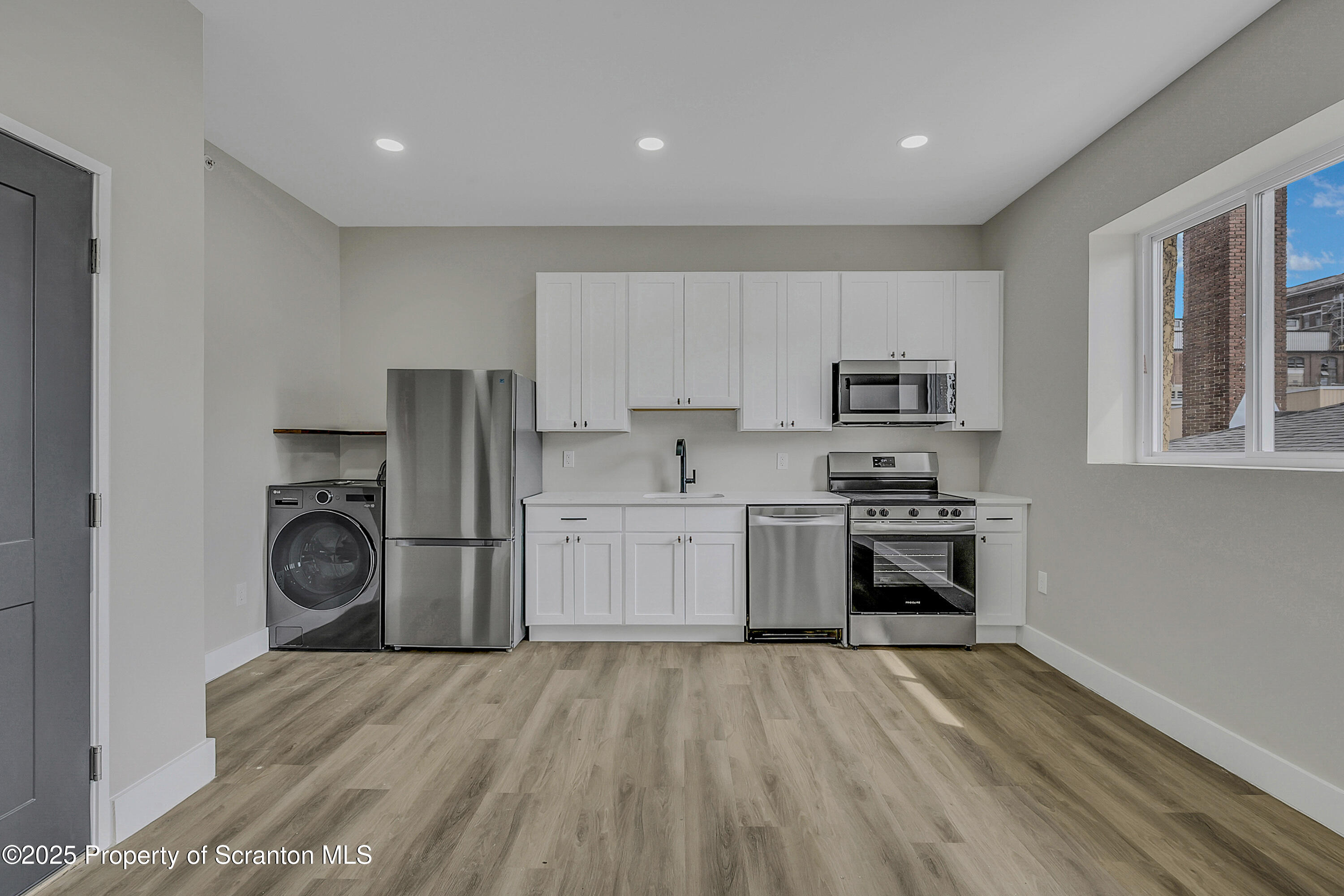 215 Hickory Street, Unit 8 Scranton, PA 18505 - Photo 4 of 18 a kitchen with granite countertop white cabinets and stainless steel appliances