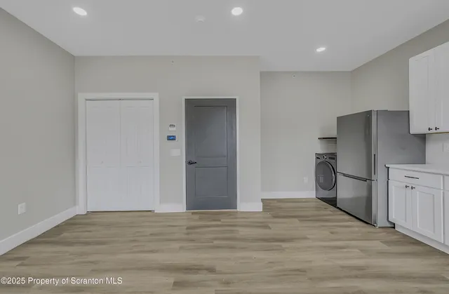 a view of a kitchen with a refrigerator cabinets and wooden floor