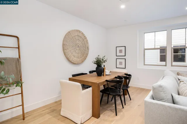 a kitchen with kitchen island a stove a sink a refrigerator and white cabinets with wooden floor