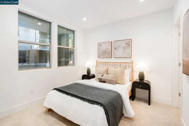a bedroom with a bed and a view of living room