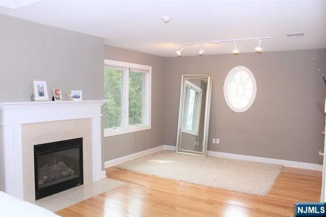 a view of a livingroom with a fireplace window and wooden floor